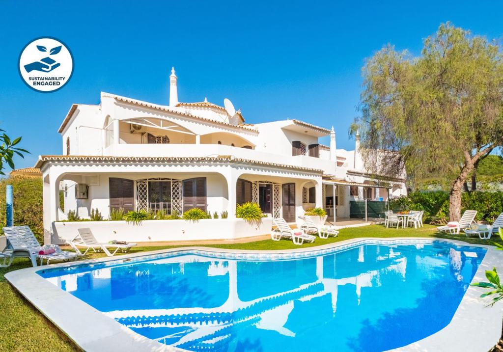 a house with a swimming pool in front of it at Villa Phi Phi - com piscina privada em Vilamoura in Quarteira