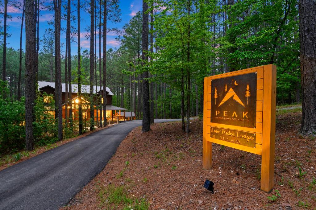 a sign in the middle of a road in the woods at Low Rider Lodge - Backs to Pine Forest and ATV Trail Access from Driveway in Broken Bow