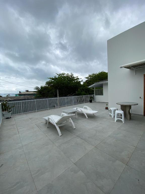 a group of white benches sitting on a patio at Pousada Baia dos Golfinhos in Governador Celso Ramos