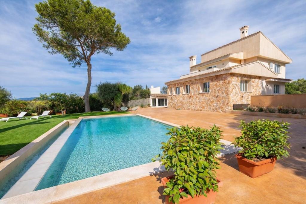 a villa with a swimming pool in front of a house at Can Luciana in La Aranjasa