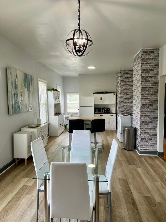 a dining room with a glass table and white chairs at Midtown Detroit Upper Retreat in Detroit