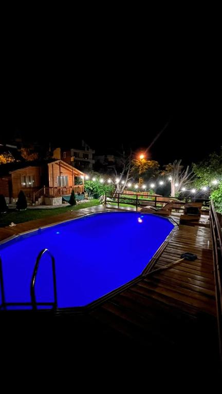 a blue swimming pool at night with lights at Guest House „ Mountain Rest“ in Lilyanovo