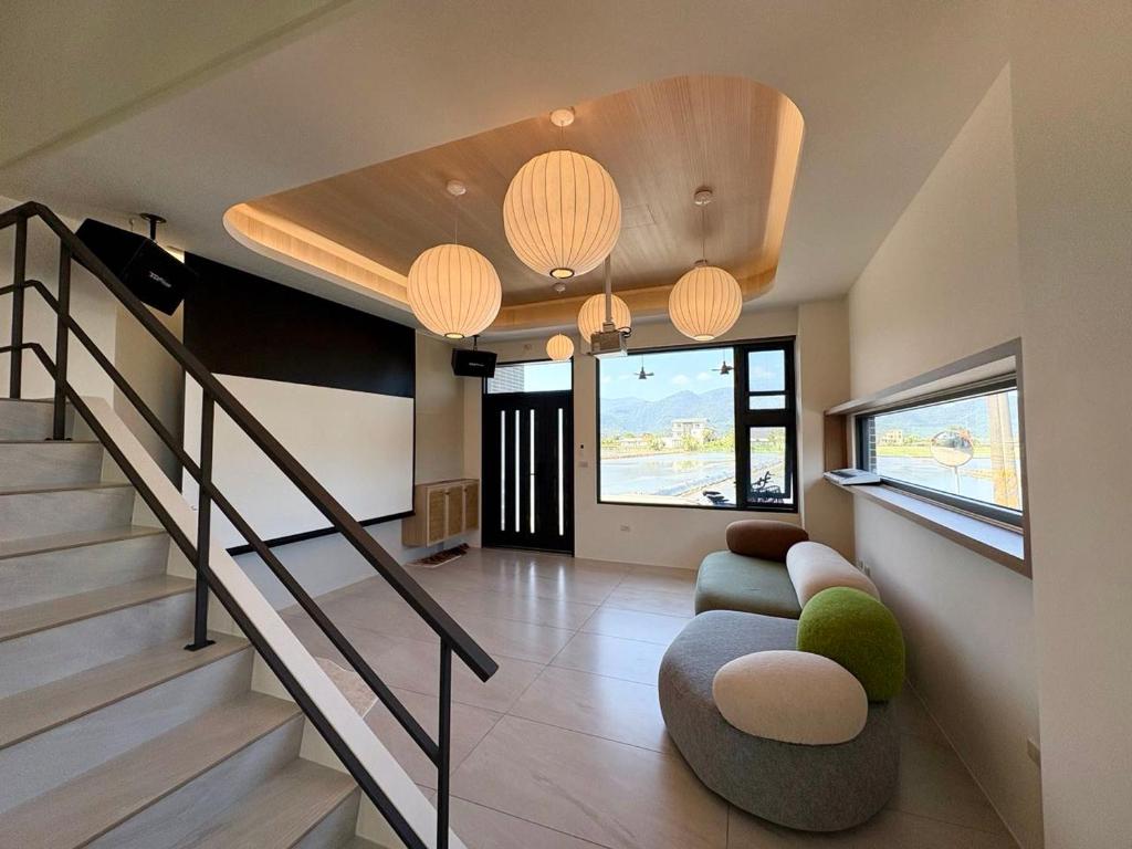 a living room with a staircase and a couch at 八樂宿 包棟民宿 in Sanxing
