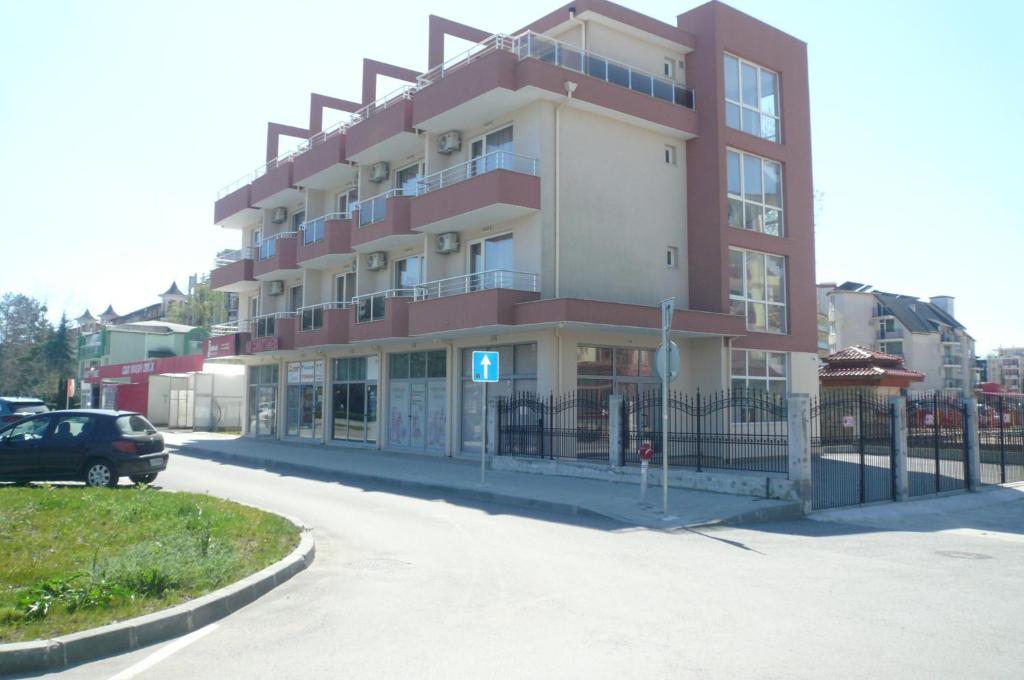 a building with a car parked in front of it at Family Hotel PUDEV in Sunny Beach