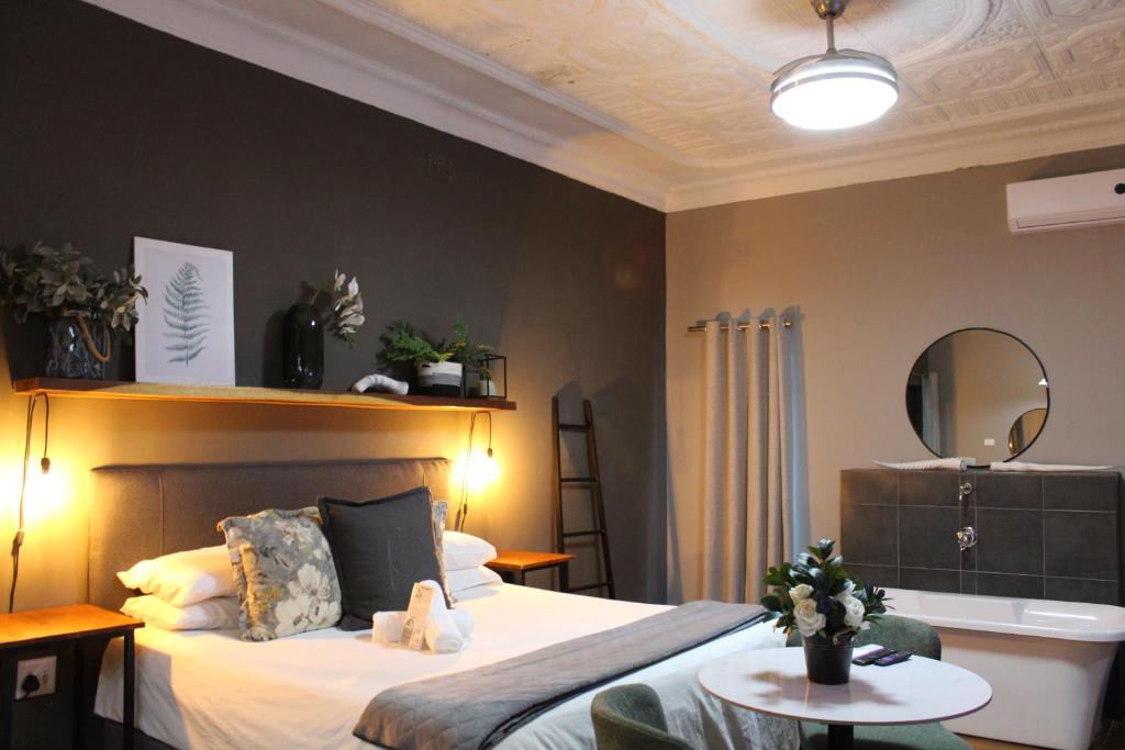 a bedroom with a bed with a mirror and a table at Stay Local Potchefstroom in Potchefstroom