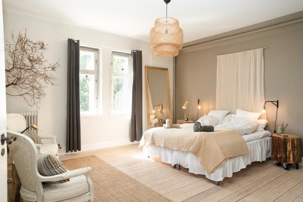 a bedroom with a bed and a chair at Edelsminde Bed & Breakfast in Haslev