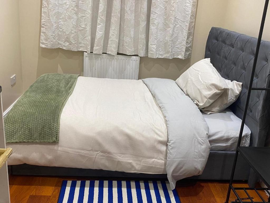 a bed with white sheets and pillows and a window at Standish Haven Ensuite Room in Standish