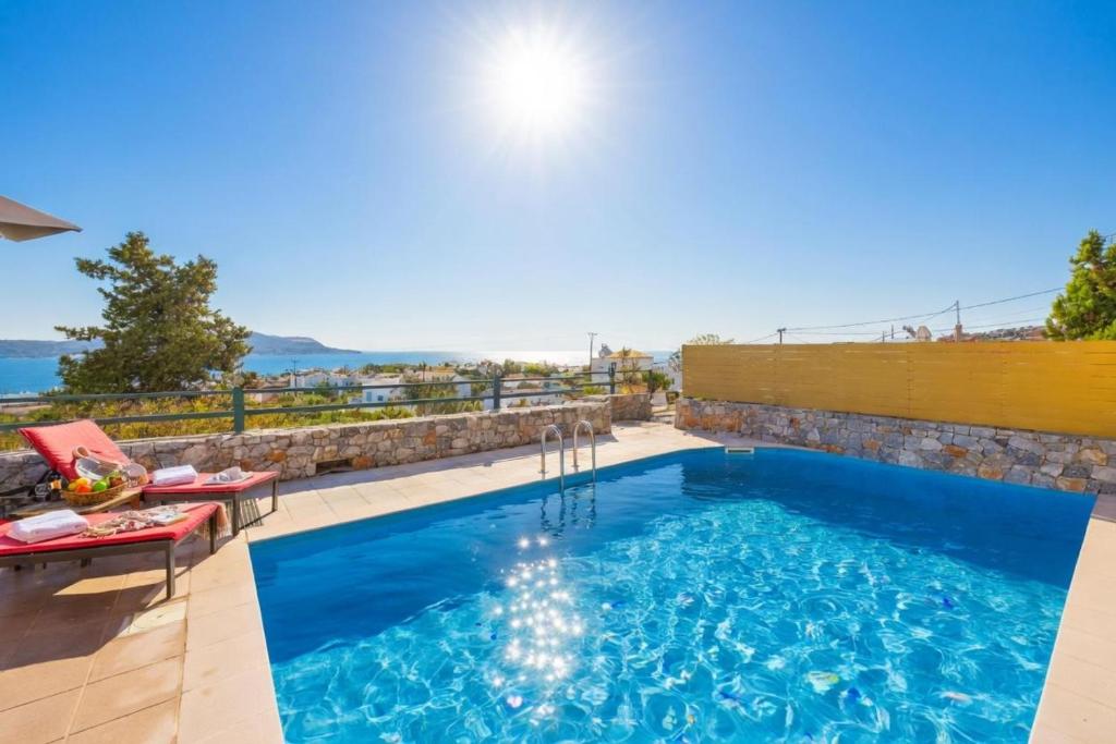 a swimming pool with a view of the water at Odysseus Villa in Plaka