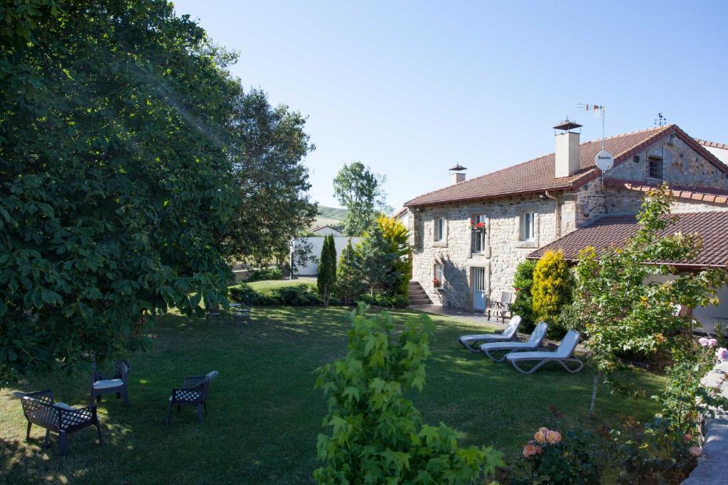 einen Hof mit mehreren Stühlen und ein Haus in der Unterkunft Casa del Lago de Campoo in Orzales