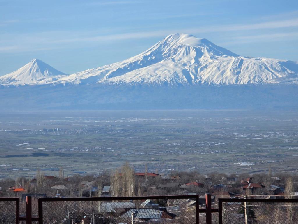 a view of snow capped mountains in the distance at Madoyans Rest House in Antarut