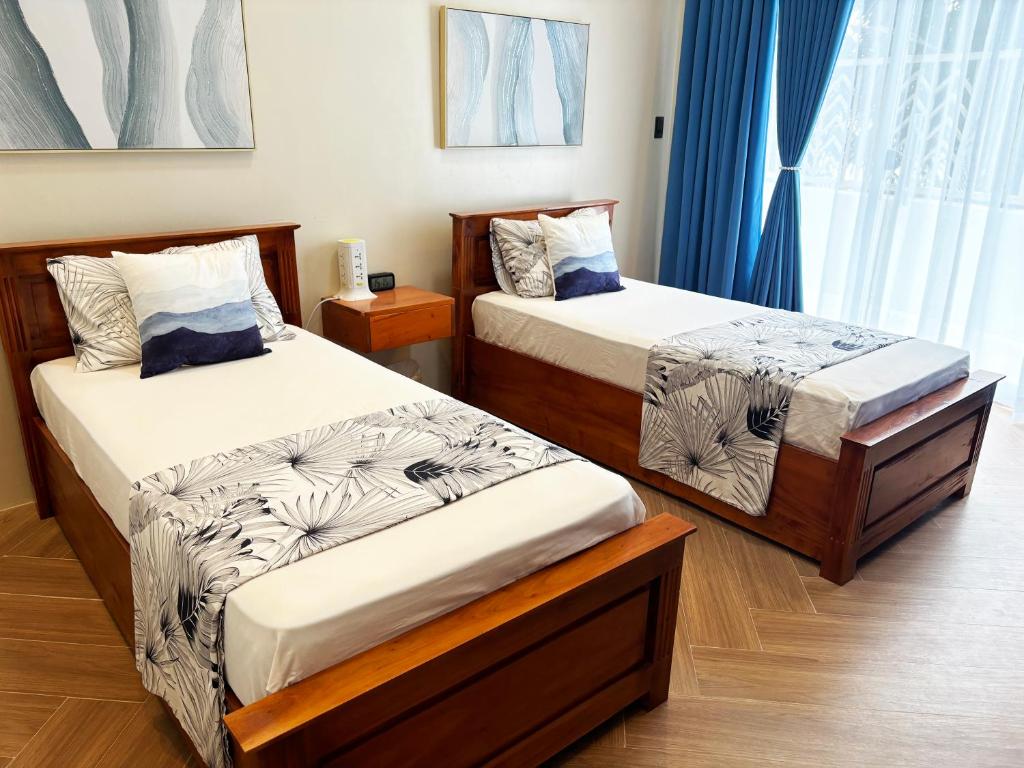 a bedroom with two beds and a window at Seawave Beach and Dive Resort in Lobo
