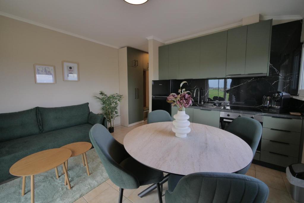 a living room with a table and a green couch at Aithra Suite - Europa Hotel in Korinos