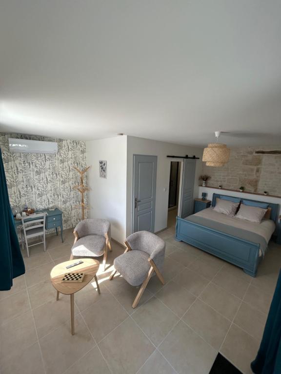 a bedroom with a bed and a table and chairs at Ô Ptit Verger in Coulon