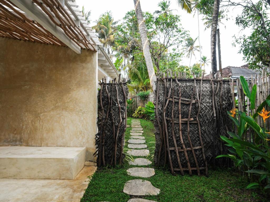 a garden with a fence and a walkway at Studio K Ahangama in Ahangama