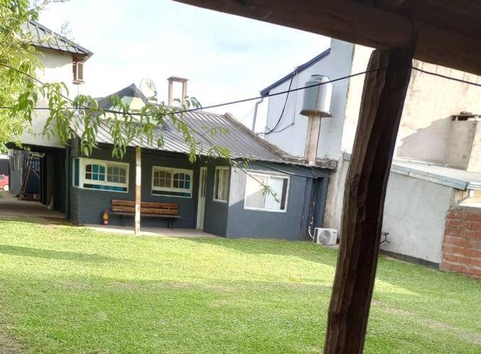 a house with a bench in front of a yard at El Rancho del Tucu in Colón