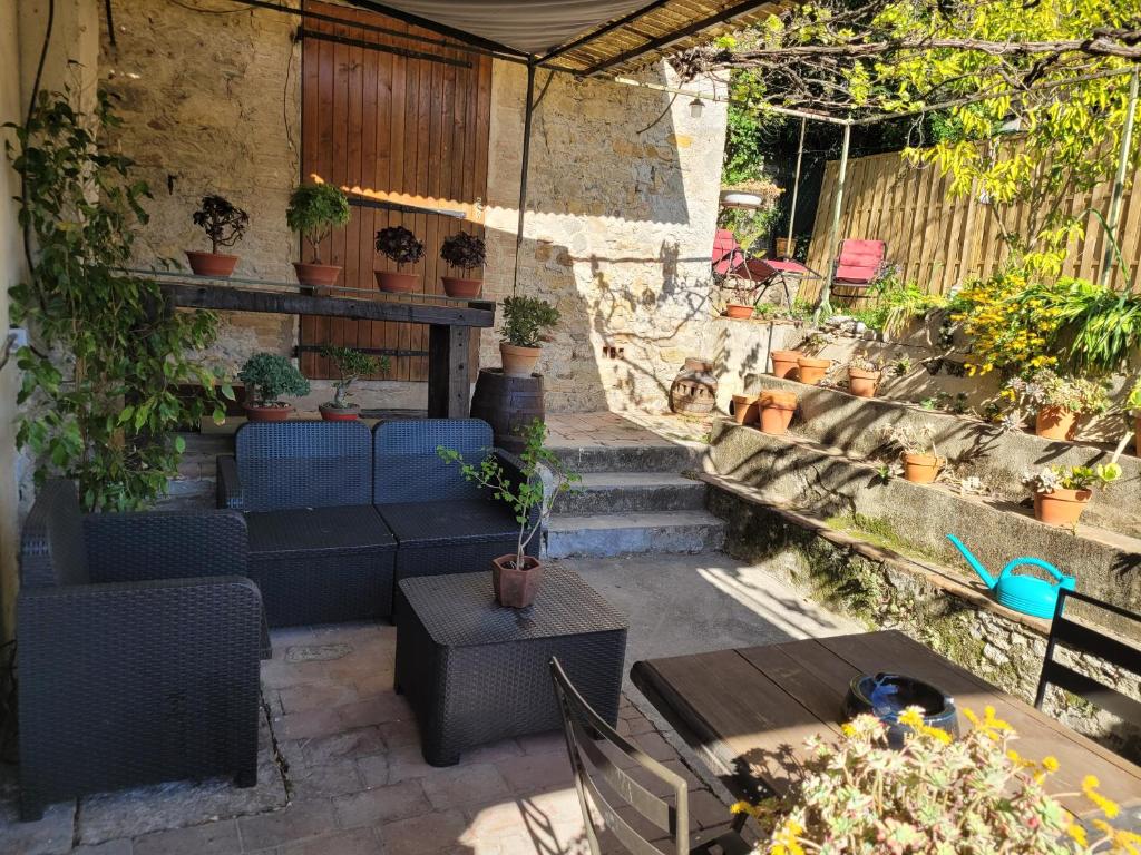 a patio with chairs and tables and potted plants at Maisonnette avec terrasse sur le Gardon in Anduze