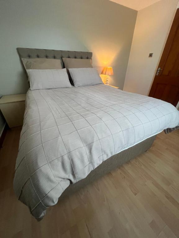 a bedroom with a large bed with a white comforter at Cozy Room at Willow House in Leyland