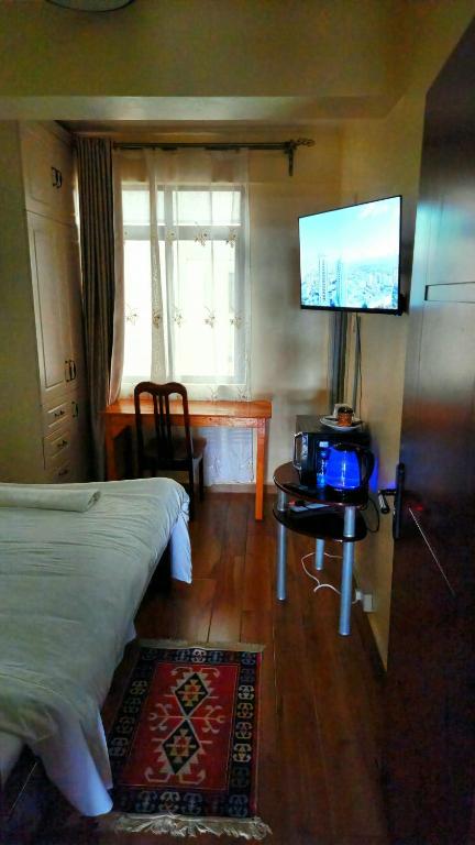 a bedroom with a bed and a flat screen tv at Sky Nest 14 in Nairobi