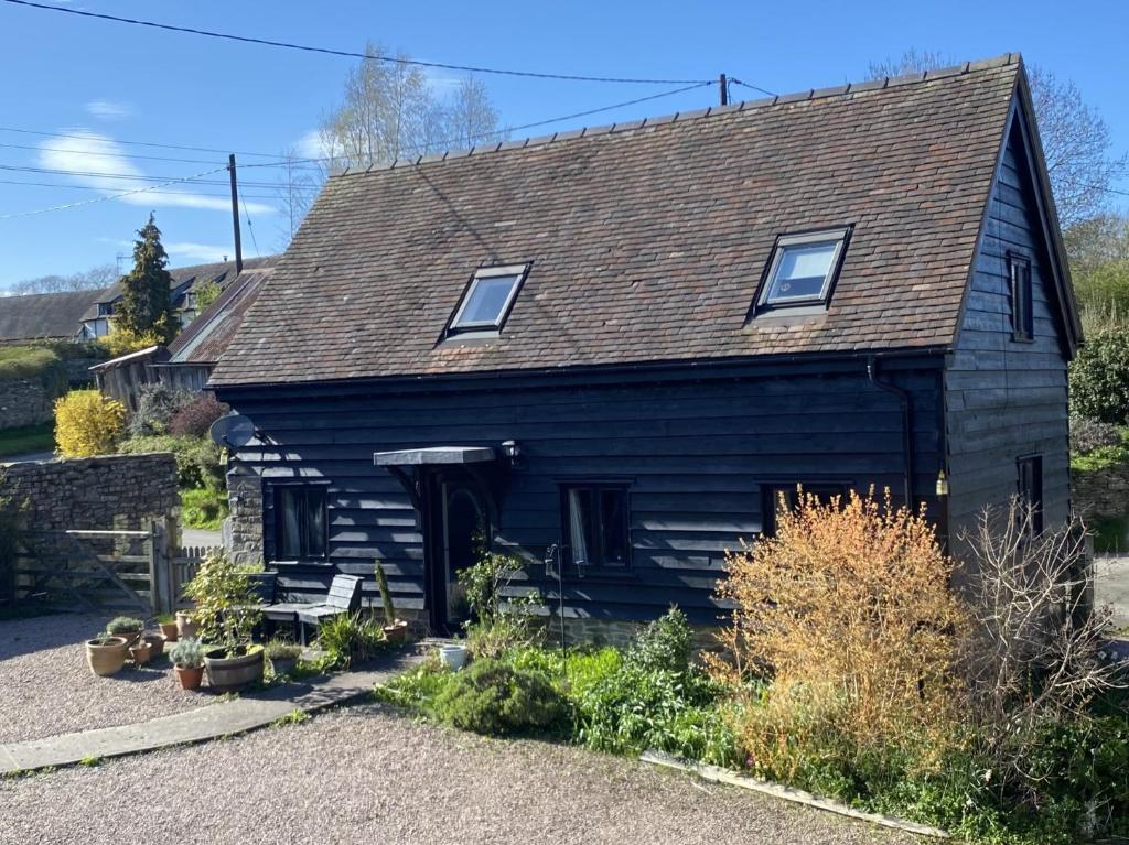 a black house with a gambrel roof at Little Drift in Edgton