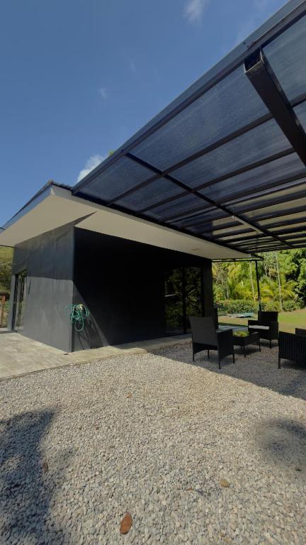 a building with a black roof with chairs and tables at Casa Benedicion in Pavones