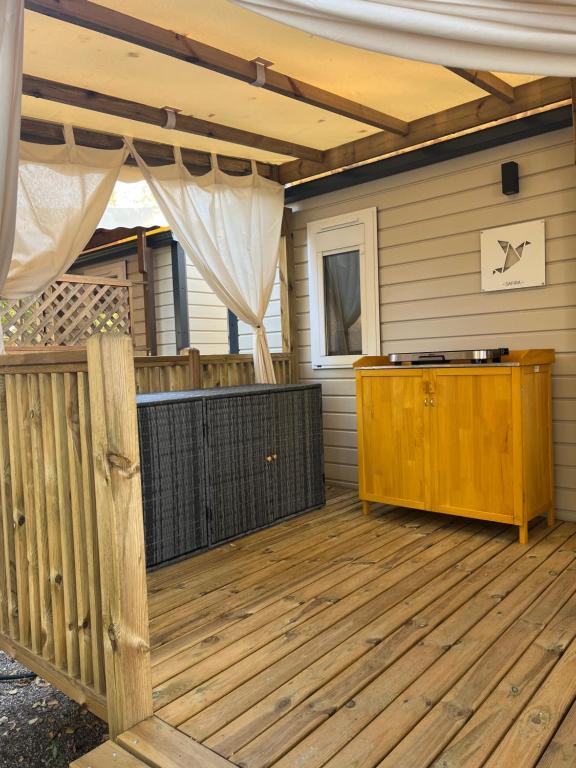 a patio with a wooden deck with a wooden fence at MA105 Le Mazet in Vias