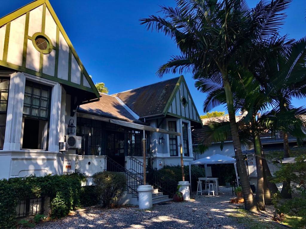 a house with a palm tree in front of it at Hotel Posada de 1860 in Tigre
