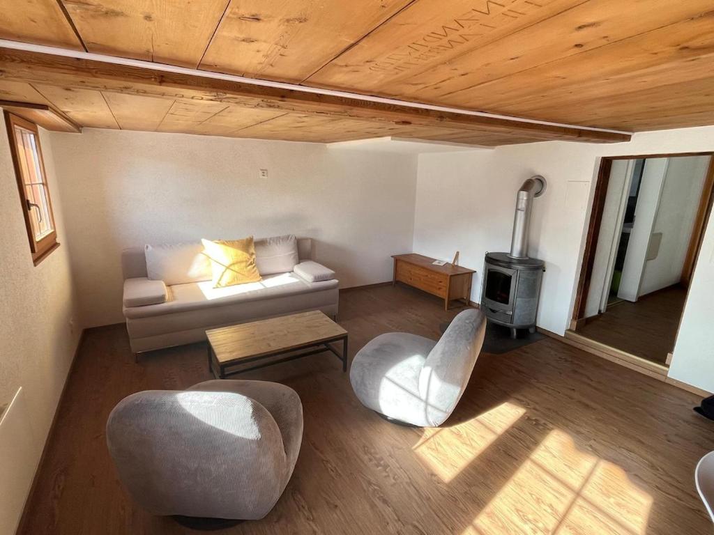 a living room with a couch and a stove at Appartement entier dans chalet traditionnel in Bratsch