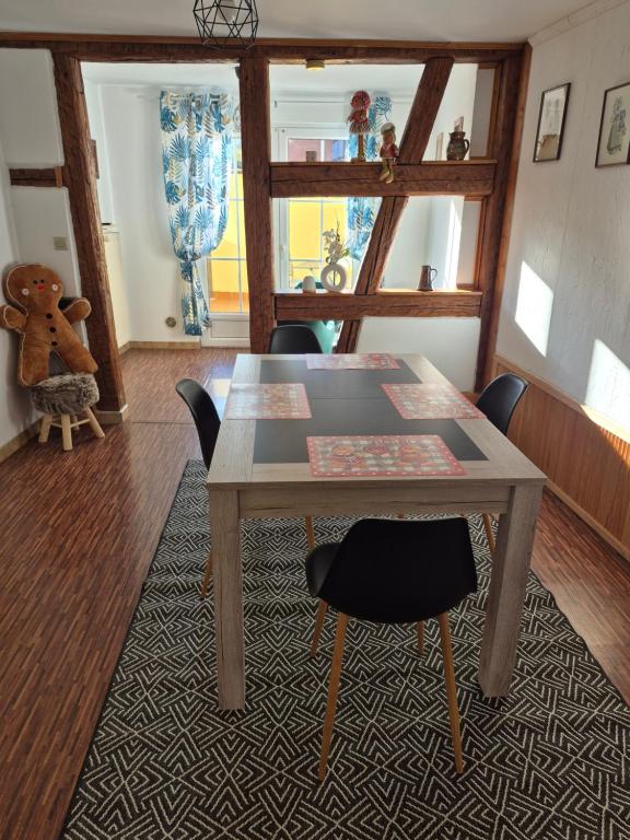 a dining room with a wooden table and chairs at Le repaire des Manalas in Ingersheim