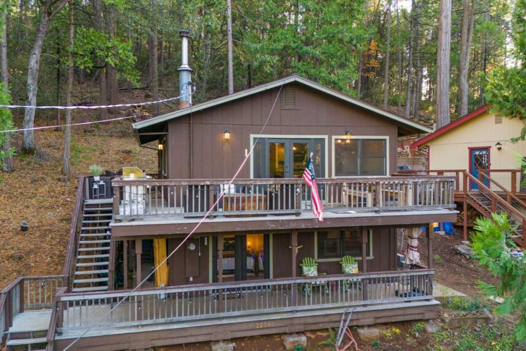 a house with a large deck in the woods at Hot Tub - Huge Deck - Lake Access in Twain Harte