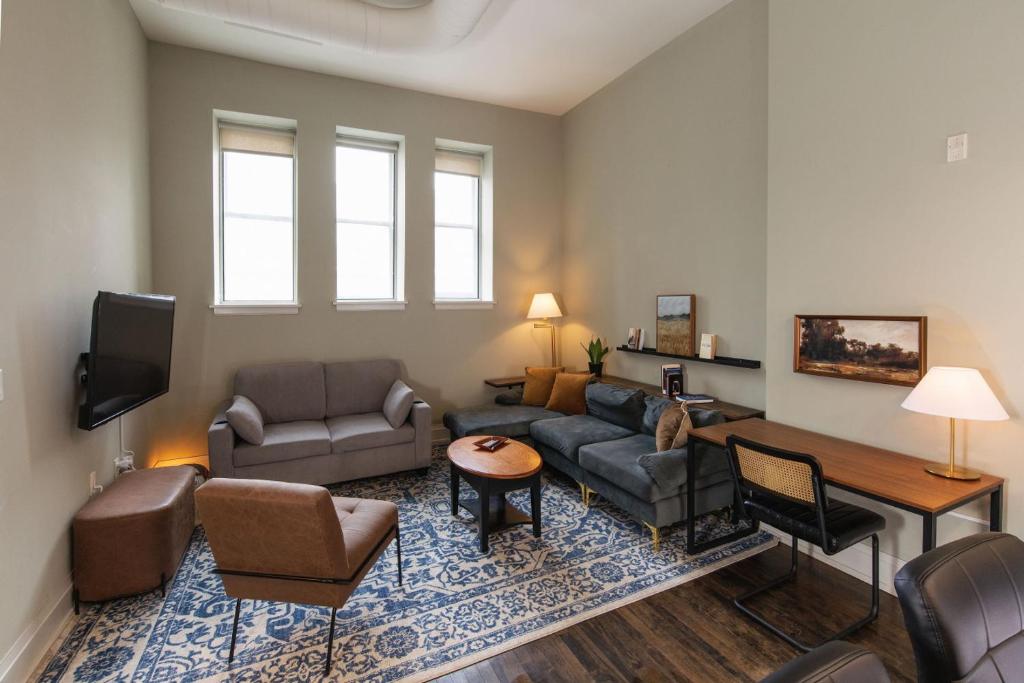 a living room with a couch and a tv at Downtown Luxe 2BR Loft Apt | Prime Location | Sleeps 10 in Milwaukee