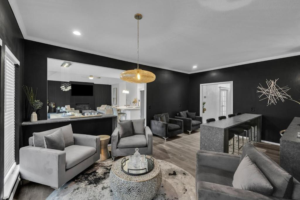 a living room with a couch and chairs and a bar at The Tulsacation 2 in Tulsa