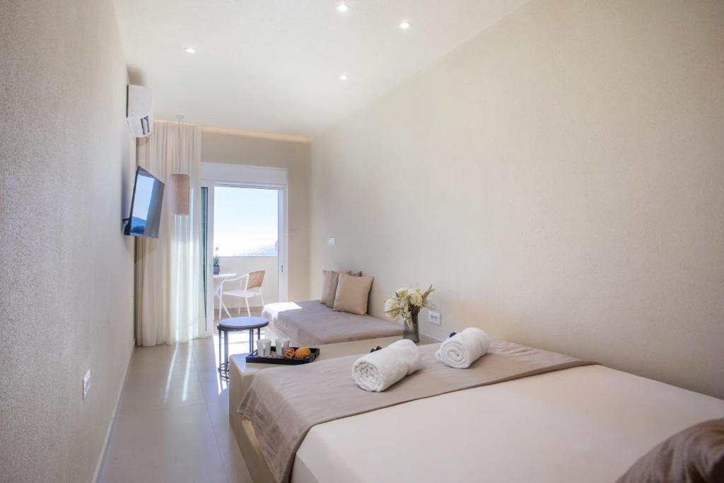 a hotel room with two beds and a television at Charaki Rest Point in Haraki