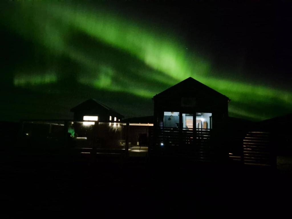 an image of a house with the aurora in the sky at Northern Lights Cabin - Syribr in Grímsnes og Grafningshreppur