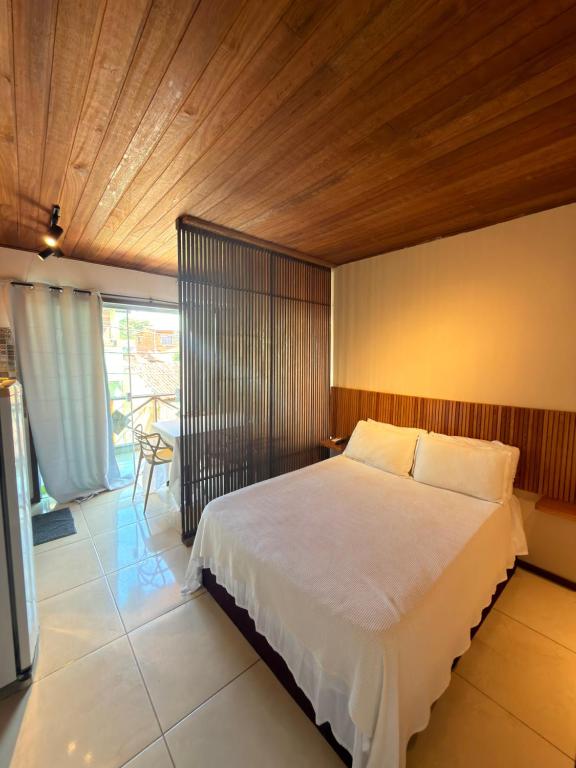 a bedroom with a large bed with a wooden ceiling at Pituba Vile - Apartamento Mandala in Itacaré