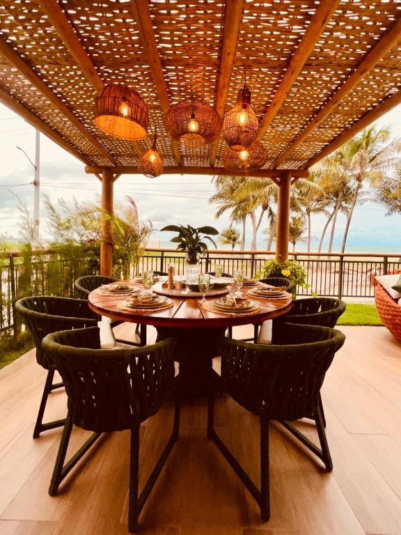 a dining room with a table and chairs on a patio at House Paraíso Flecheiras in Trairi
