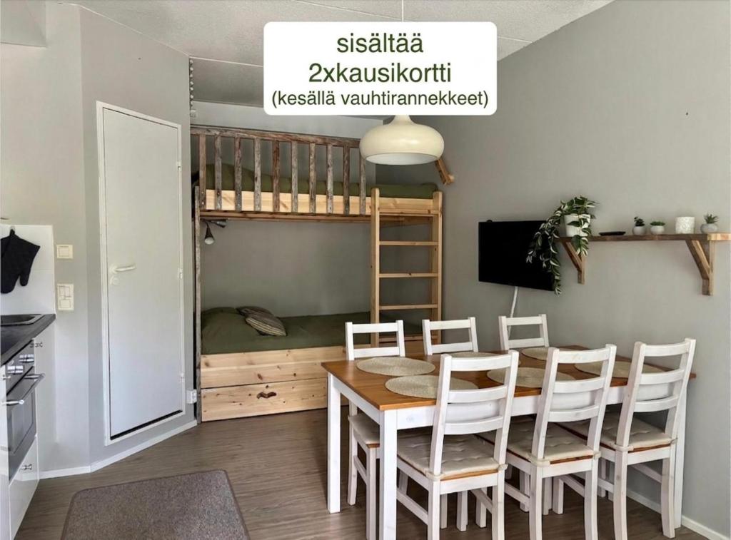 a dining room with a table and chairs and a bed at Sisältää 2x Ruka ranneke - kausikortit kesä&talvi - Vuosselin Helmi C11 in Ruka