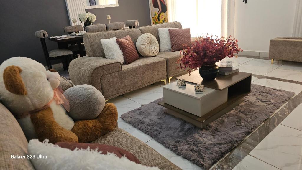 a living room with a teddy bear sitting on a couch at VVVIP lita Résidence in Ekoumdoum