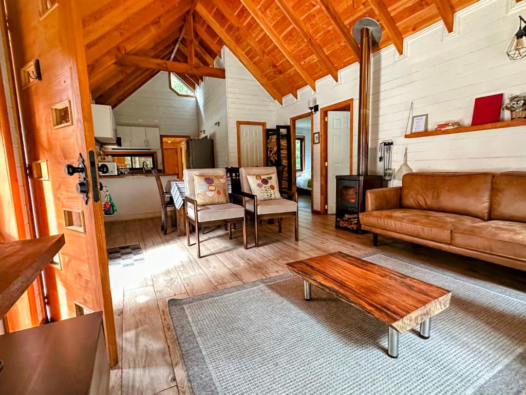 a living room with a couch and a table at Cabañas Alto del Bosque in Coñaripe