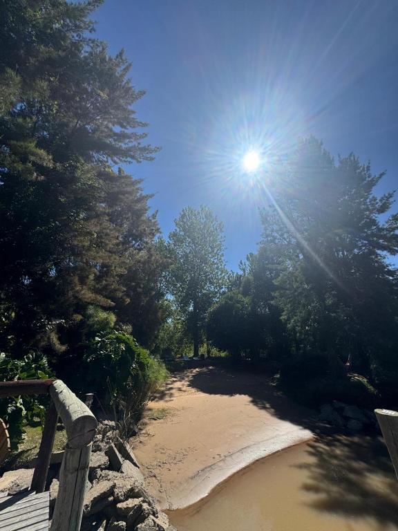 a sun shining on a sandy path with trees at Cabañas Allende Delta in Tigre