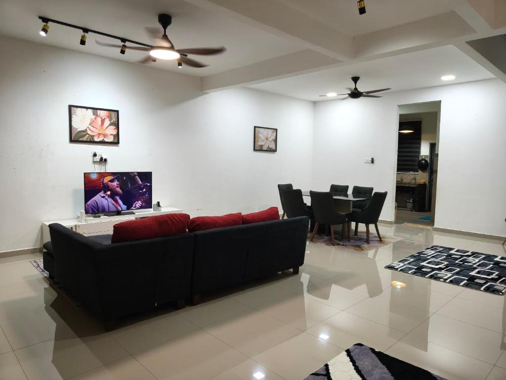 a living room with a couch and a dining room at Atabara ECRL Stay Homestay in Kuantan