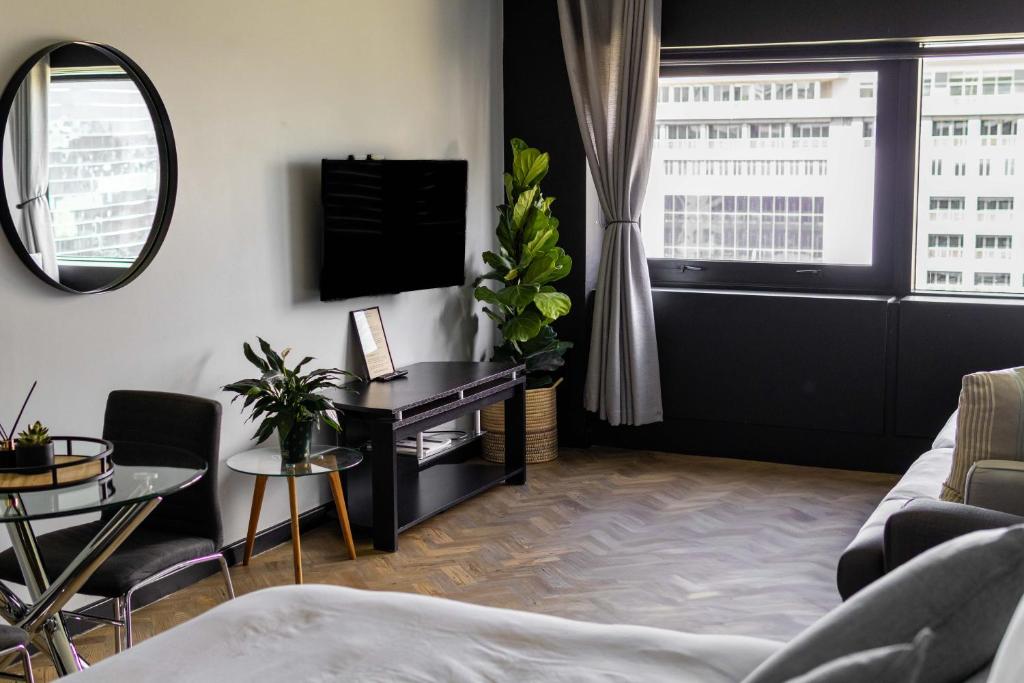 a living room with a couch and a mirror at Onyx Studio Apartment in Cape Town
