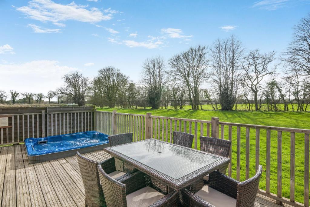 a patio with a table and chairs on a wooden deck at Primrose 2 bed-No Pets-Daisy in Eye
