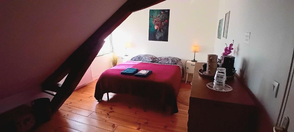 a bedroom with a red bed and a wooden floor at Chez ISA chambre chez l'habitant Léa in Montlouis-sur-Loire