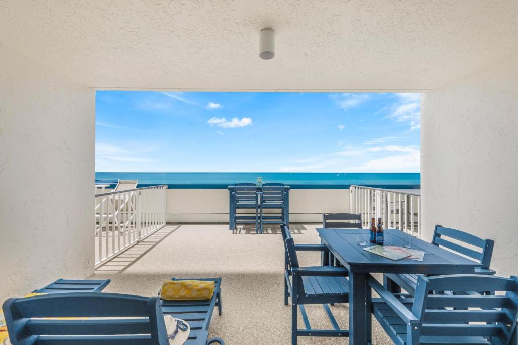 a dining room with a table and chairs on a balcony at Apollo 207 in Marco Island