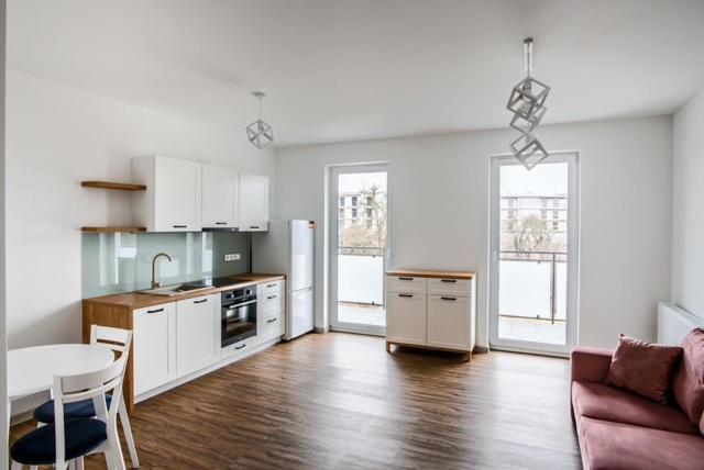 a kitchen with a couch and a table in a room at Apartament Różany 2 in Busko-Zdrój