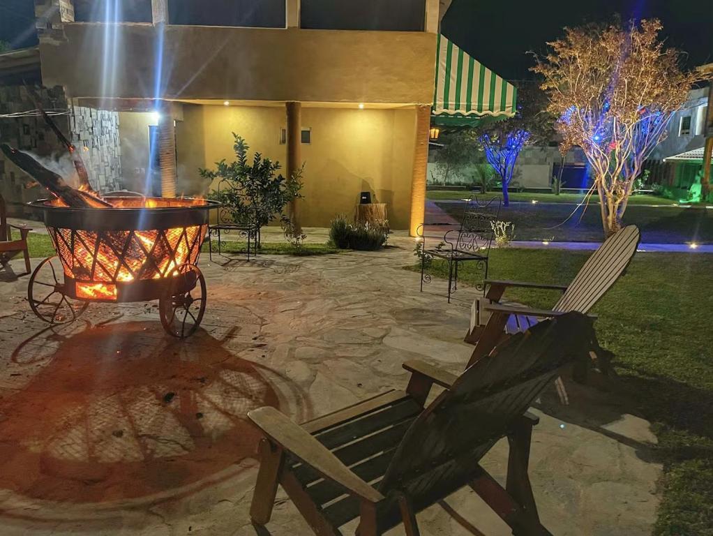 a patio with a fire grill and two chairs at Hotel Casa Patrón Parras in Parras de la Fuente