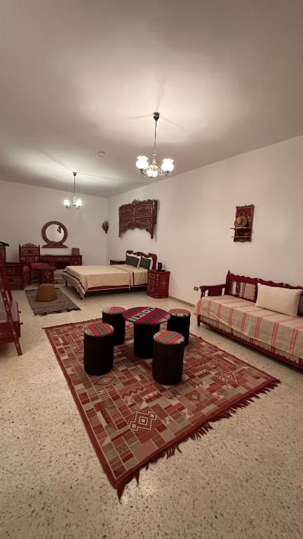 a large room with two beds and a rug at Dar morjana in Chott Meriem