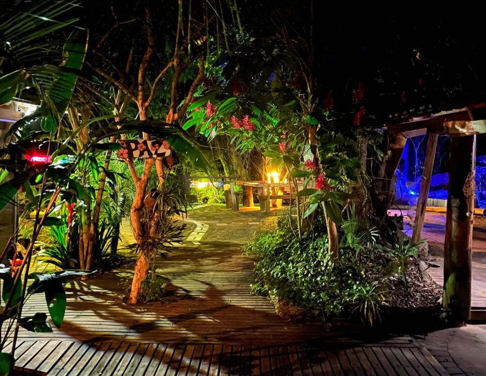 a garden at night with trees and plants at Mato Verde Hospedaria - À beira da Lagoa - Praia do Rosa in Imbituba