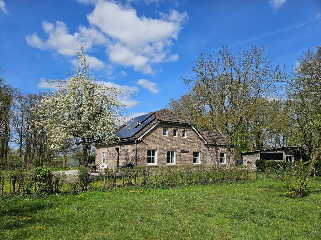 an old brick house in a field of grass at Die alte Waldkate - Windschief und mitten in der Natur in Kevelaer