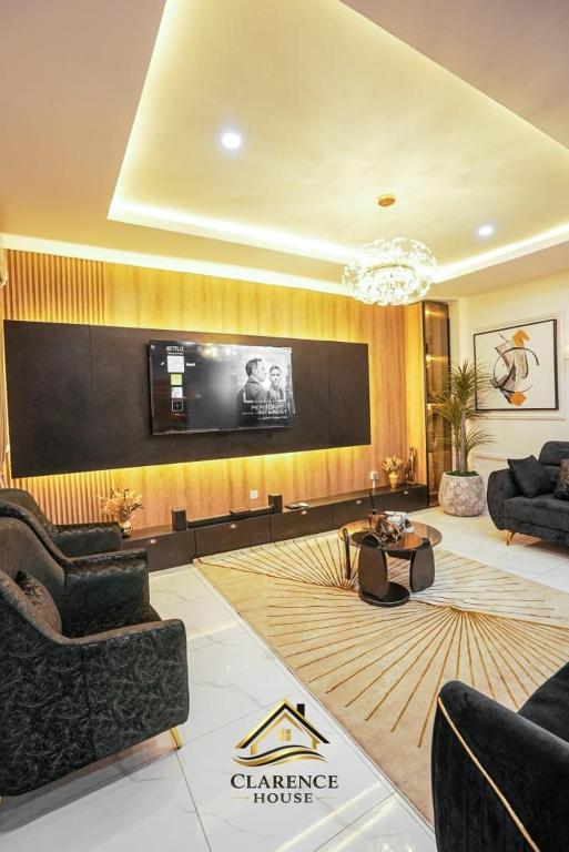 a living room with a tv on a wall at Clarence House in Ikeja